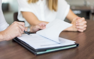 dos personas firmando un documento